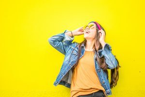 smiling-woman-looking-upright-standing-against-yellow-wall-1536619-300x200-3215627